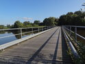 Ocelový most s dřevěnými fošnami přes řeku Sude, pravobřežní přítok Labe.