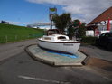 Kasjopea je motorový člun vystavený pod vysokou pobřežní hrází v obci Friedrichskoog-Spitze.