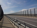 Elbebrücke Mühlberg a silnice L66 se skleněnými kryty po obou stranách.