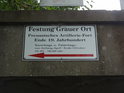 Turistická cedule k pevnosti Grauer Ort informuje o otevírací době.
