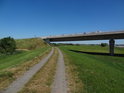 Dlážděné koleje cyklostezky na levém břehu Labe v Tangermünde vedou pod silniční most.