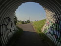Veliký husí krk jako tunel cyklostezky v železničním násypu u mostu přes Labe v Torgau.