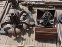 Přední část pracovní lodi kotvící v přístavu Wittenberge s drapáky na palubě.